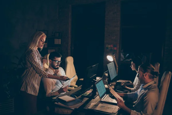 Profile side view of nice attractive focused coworkers experts developing department statistics income analyzing report at night at work place station dark room — Zdjęcie stockowe