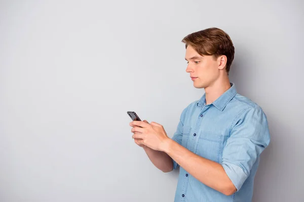 Turned photo of concentrated worker guy use smartphone chatting with colleagues clients on social media text type sms wear good looking outfit isolated over grey color background