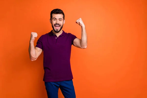 Portrait of delighted lucky man hear lottery win news scream yeah raise fists wear modern hipster youth outfit isolated over orange color background — 图库照片