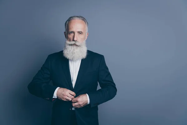 Retrato de su bonito atractivo elegante elegante serio hombre de pelo gris macho dandy usando botón de fijación de esmoquin aislado sobre fondo de color pastel gris oscuro — Foto de Stock