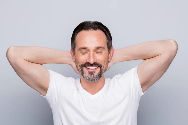 Photo of handsome mature man guy holding hands behind head peaceful mood enjoy salon rejuvenation procedure relaxing eyes closed wear white t-shirt isolated grey color background — Stock Photo, Image