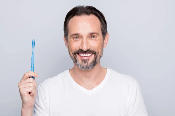 Close-up foto van volwassen man met hand nieuwe tandenborstel adviseren goede kwaliteit mooie prijs geweldig resultaat dragen witte t-shirt geïsoleerde grijze kleur achtergrond — Stockfoto