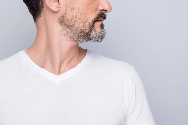 Närbild beskärda foto av attraktiva äldre man allvarligt ser sida tomt utrymme mogen rynkor utseende visar vacker skägg slitage vit t-shirt isolerad grå färg bakgrund — Stockfoto