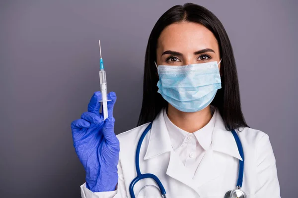 Foto de cerca de la mujer doctora experimentada que usa máscara preparar jeringa con insulina curar la inflamación del virus epidémico tienen estetoscopio de capa blanca aislado sobre fondo de color gris — Foto de Stock