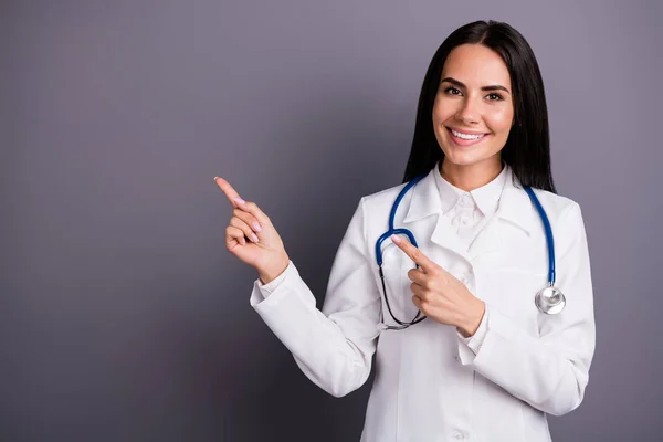 Close-up retrato dela ela agradável atraente menina morena confiante mostrando espaço de cópia assistência médica profissional ajuda consulta de seguro nova novidade isolada no fundo de cor pastel cinza — Fotografia de Stock