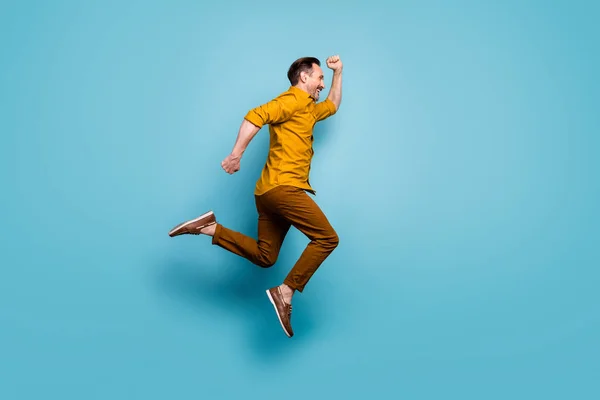 Full size profil stronie zdjęcie wesoły pozytywny człowiek skok uruchomić po wiosna czas sprzedaży nosić casual styl strój trampki izolowane na tle niebieskiego koloru — Zdjęcie stockowe