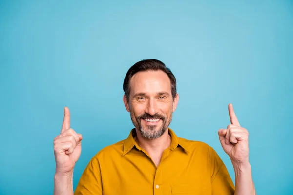 Retrato de hombre fresco alegre positivo promotor punto dedo copyspace demostrar opción anunciar descuentos de ventas desgaste ropa de estilo casual aislado sobre fondo de color azul — Foto de Stock