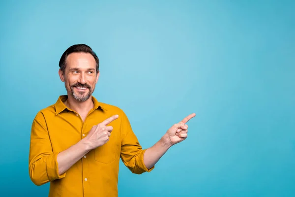 Retrato de hombre alegre positivo punto dedo copyspace indican descuentos de ventas publicidad de promoción usar ropa elegante aislado sobre fondo de color azul — Foto de Stock