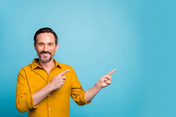 Портрет позитивного человека промоутер указатель пальца копирайта указывает рекламу промо носить повседневную одежду стиле изолированы на синем фоне цвета — стоковое фото