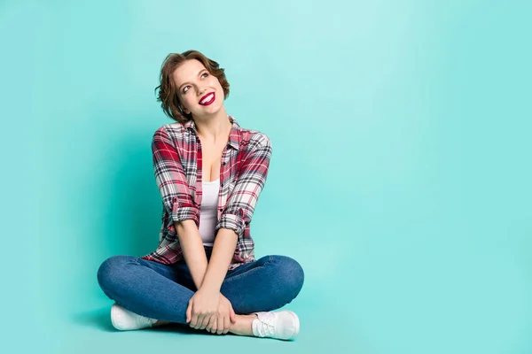 Foto em tamanho completo de sonhador mente menina sentar pernas cruzadas olhar bom espaço cópia imaginar seus fins de semana perfeitos usar roupa estilo casual isolado sobre fundo cor verde — Fotografia de Stock