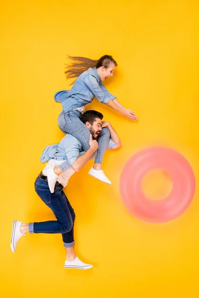 Vertical top view above high angle flat lay flatlay lie full length body size view concept of cheerful cheery spouses flying having fun isolated on bright vivid shine vibrant yellow color background — ストック写真