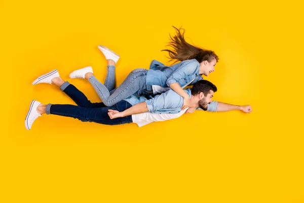 Top view above high angle flat lay flatlay lie full length body size view concept of cheerful beautiful spouses flying embracing isolated on bright vivid shine vibrant yellow color background — стоковое фото