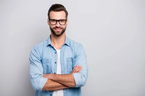 Foto av attraktiv kille ung befordrad chef händerna korsade självsäker person vänliga leende kollegor bära specs casual denim outfit isolerad grå färg bakgrund — Stockfoto