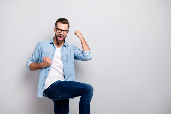 Foto di attraente selvaggio pazzo business ragazzo eccitato emozioni successo avvio progetto di investimento alzare i pugni indossare specifiche casual denim vestito isolato colore grigio sfondo — Foto Stock