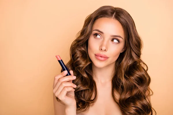 Cerca de la foto de la encantadora chica mantenga pomada tratar de comprobar pensar en el nuevo efecto de brillo de los labios palo aislado sobre fondo de color pastel — Foto de Stock