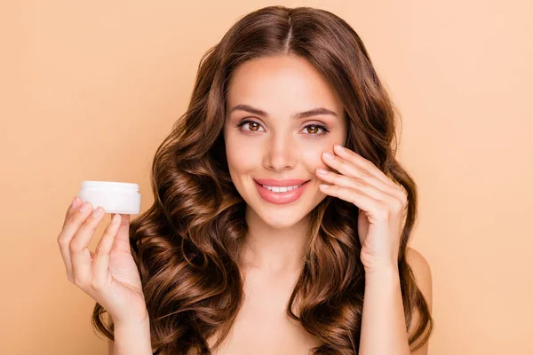 De cerca foto de chica rizada encantadora positiva aplicar tarro de crema para hacer la piel suave perfecta impecable suave aislado sobre fondo de color beige pastel — Foto de Stock