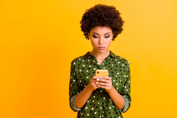 Πορτρέτο του εστιασμένου afro american smm εργαζόμενο κορίτσι χρήση smartphone διαβάστε τα μέσα κοινωνικής δικτύωσης φορούν κομψό φωτεινό στολή απομονώνονται σε κίτρινο χρώμα φόντο — Φωτογραφία Αρχείου
