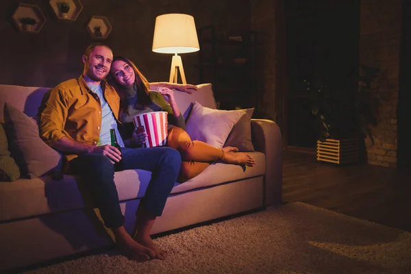 Schöne attraktive schöne fröhliche fröhliche Paar Mädchen sitzen auf Diwan genießen Snack Film verbringen Tag Wochenende Urlaub in der Nacht dunkel Haus Wohnung drinnen — Stockfoto