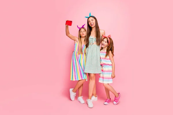 Full storlek foto av kvinna och två skolbarn med lång blond brunett frisyr skicka luft kyssar gör selfie bära kjol pannband isolerad rosa bakgrund — Stockfoto