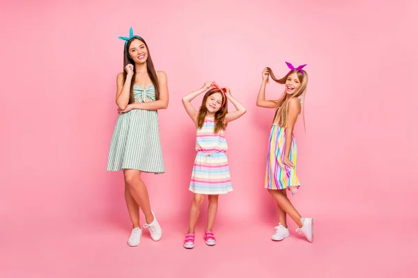 Full size foto van mooie meisjes met heldere hoofdbanden poseren het dragen van kleurrijke jurk rok geïsoleerd over roze achtergrond — Stockfoto