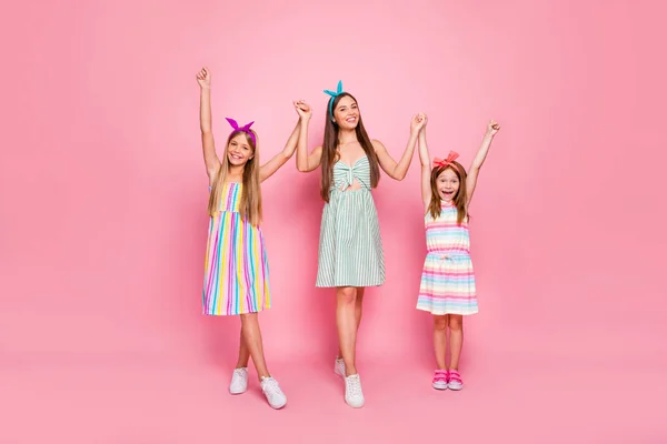 Foto de cuerpo completo de señoras alegres con diademas levantando las manos usando diademas de vestido de falda brillante aisladas sobre fondo rosa —  Fotos de Stock