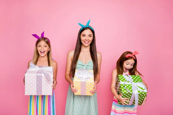 Retrato de hermanos alegres con diademas en el peinado largo consiguen caja de regalo para 8-marzo con vestido de falda aislado sobre fondo rosa — Foto de Stock