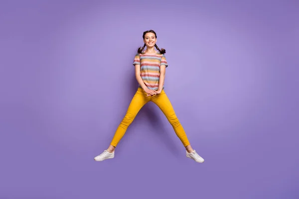 全长照片，滑稽女士跳夏高气爽阳光灿烂的天气穿休闲条纹T恤黄裤子孤立的紫色背景 — 图库照片