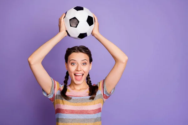 Portrét vzrušený funky teenager dívka držet fotbalový míč podporu její tým hrát světový pohár zápas vyhrát vítězství křičet wow omg nosit mládež moderní oblečení izolované přes fialové barvy pozadí — Stock fotografie