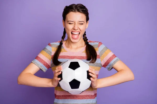 Bláznivý vtipný dospívající dívka držet fotbalový míč navštívit finále ligy mistrovství hra podporu svého týmu křik jít jít nosit moderní mladík oblečení izolované přes fialové barvy pozadí — Stock fotografie