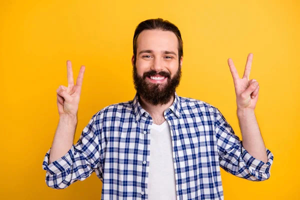 Primo piano ritratto del suo bel attraente allegro allegro ragazzo barbuto funky bruna in camicia a quadretti mostrando doppio v-segno isolato su brillante brillantezza vivace colore giallo sfondo — Foto Stock