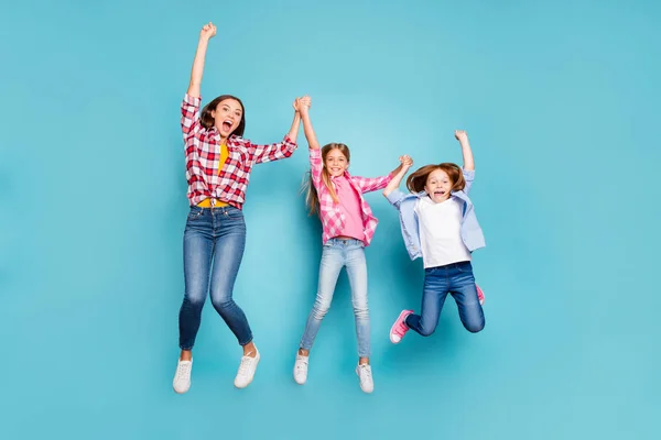 Full size foto corpo lunghezza di due figlie gioire con la madre vincente gioire bianco indossare jeans denim mentre isolato con sfondo blu — Foto Stock