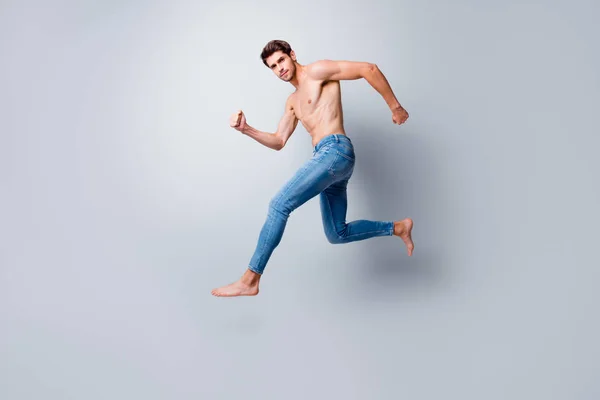 Πλήρες μέγεθος προφίλ φωτογραφία του εστιασμένου άντρα macho άλμα υψηλό τρέξιμο τόπλες κορμό metrosexual καυτό σώμα ανταγωνιστική διάθεση φορούν μόνο τζιν απομονωμένο γκρι φόντο — Φωτογραφία Αρχείου
