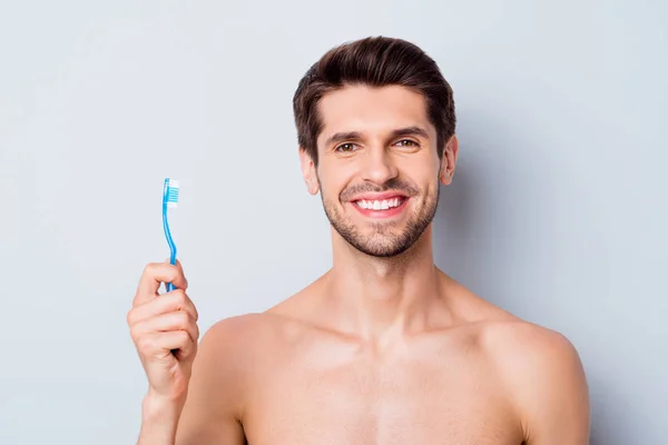 Close-up retrato de seu belo atraente barbudo alegre cara nu de cabelos castanhos segurando na mão escova de dentes aperfeiçoamento terapia gengiva isolado na luz branco cinza cor pastel fundo — Fotografia de Stock