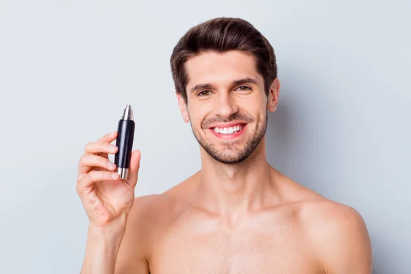 Close-up portrait of his he nice attractive bearded groomed cheerful cheery glad brown-haired guy holding in hand electric hair cutter isolated on light white grey color pastel background — Stock Photo, Image