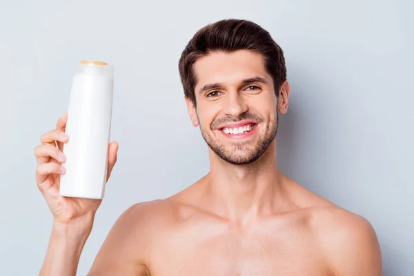 Close-up portrait of his he nice attractive bearded cheerful cheery well-groomed guy holding in hands demonstrating new product shampoo treatment isolated on light white grey color pastel background — Stock Photo, Image