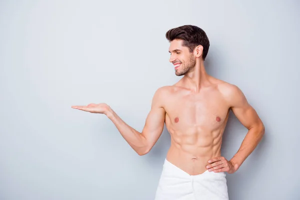 Profil Seite des schönen Macho Mann wie Hautpflege Wellness-Salon Mann Behandlung waschen Körper perfekte Lotion Conditioner Gel halten Hand empfehlen zu tragen weißes Handtuch isoliert graue Farbe Hintergrund — Stockfoto