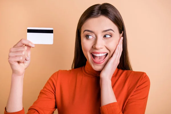 Närbild foto av glada charmiga söt trevlig flickvän har fått sin nya kreditkort glädje bär röd polotröja isolerad över beige pastell färg bakgrund — Stockfoto
