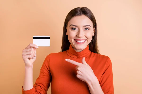 Foto av charmiga söta glada flickvän som visar dig att använda elektroniska betalningssätt är mer bekväm att hålla kreditkort med handen pekar isolerad beige pastell färg bakgrund — Stockfoto