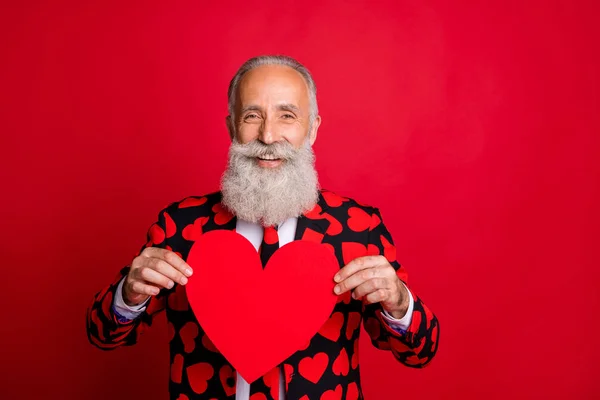 Gros plan portrait de son il agréable sympathique sympathique amical gai gai gai gars aux cheveux gris tenant dans les mains coeur en papier isolé sur brillant vif fond de couleur rouge vif — Photo