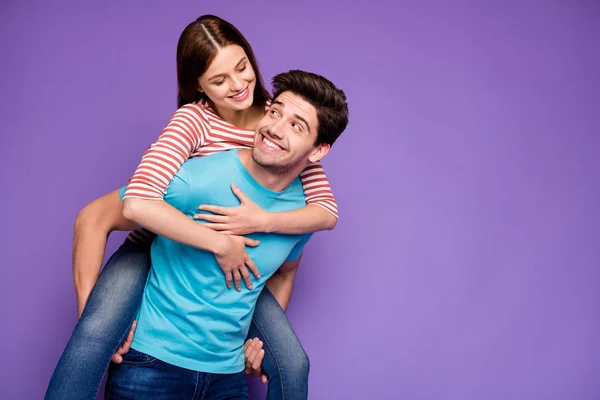 Foto de duas pessoas despreocupadas funky cara carregando senhora piggyback olhar olhos alegres aventuras no tempo livre usar casual elegante azul listrado t-shirts jeans isolado cor roxa fundo — Fotografia de Stock