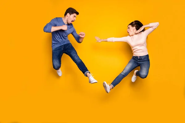 Полная длина фото пятнистые два студента люди имеют тренировки бой ногами ногами удар нога прыжок носить повседневную одежду джинсы стиле изолированы над блеском цвета фона — стоковое фото