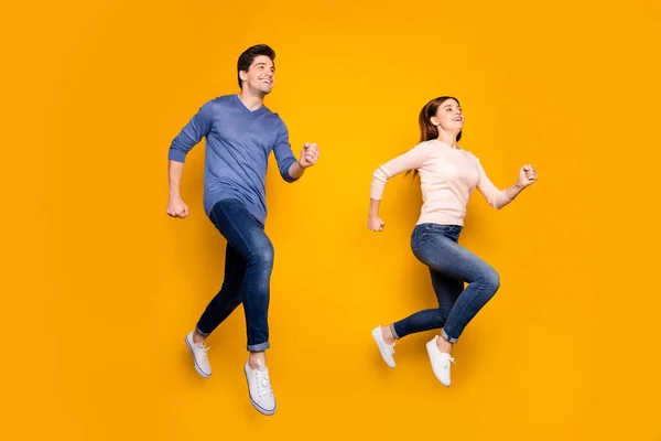 Foto de comprimento total do casal alegre salto correr rápido após o horário de verão descontos de vendas usar camisola azul rosa isolado sobre fundo cor brilho — Fotografia de Stock