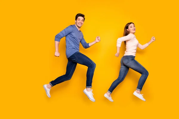 Full body profiel zijkant foto van funky bruin rood haar getrouwd stel jump run na verkoop kortingen dragen roze blauwe trui sneakers geïsoleerd over gele kleur achtergrond — Stockfoto