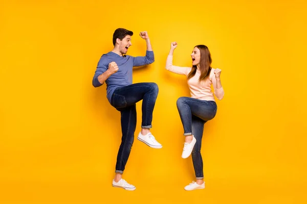 Полное фото тела восторженной эмоциональной пары праздновать победу поднять кулаки кричать Да носить джинсы джинсы кроссовки изолированы на желтом фоне — стоковое фото