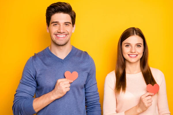 Close up photo of dreamy two people spouses celebrate 14-february hold small red paper card hearts show passionate love feelings wear good look clothes isolated yellow color background — Stock Photo, Image