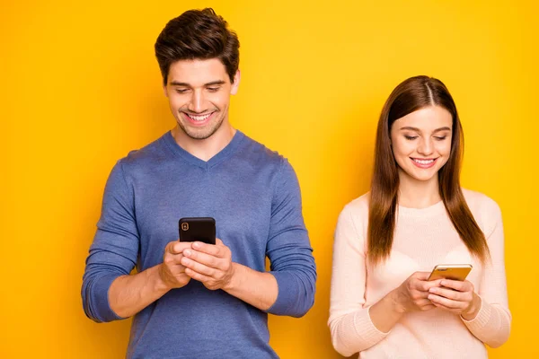 Portret van positieve twee mensen romantisch koppel gebruik smartphone lees sociaal netwerk nieuws dragen blauw roze trui geïsoleerd over heldere kleur achtergrond — Stockfoto