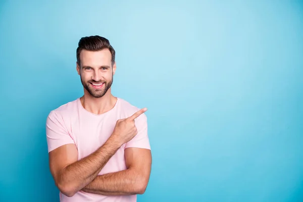 Foto de cara engraçado indicando dedo vazio espaço aconselhando legal baixos preços de desconto melhores produtos de qualidade usar casual rosa t-shirt isolado azul cor de fundo — Fotografia de Stock