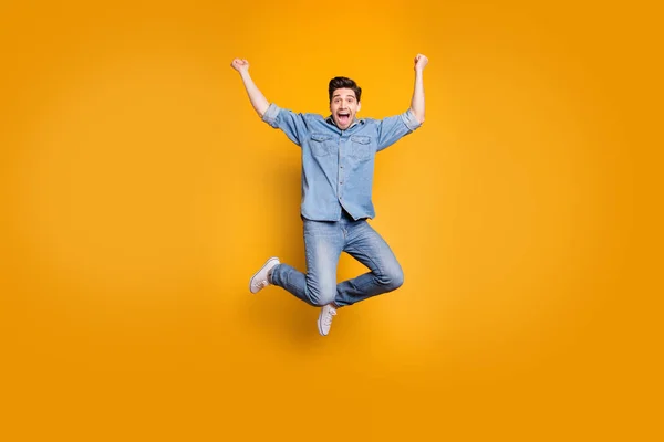 Pełna długość ciała rozmiar zdjęcie brązowe włosy szalony podekscytowany radujący się człowiek skacze w górę krzycząc izolowane na żółte żywe tło kolor — Zdjęcie stockowe