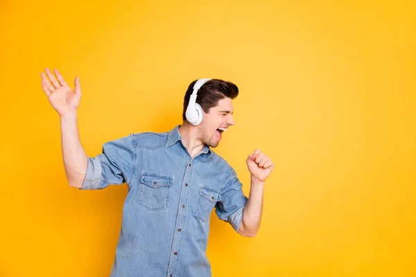 Foto di cantante pazzo urlando in microfono immaginario utilizzando cuffie wireless per l'ascolto isolato su sfondo di colore vivido — Foto Stock