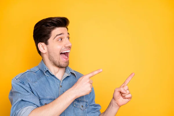 Close-up portrait of his he nice attractive funky funny glad cheerful cheery guy pointing two forefingers aside advert ad isolated over bright vivid shine vibrant yellow color background — 스톡 사진